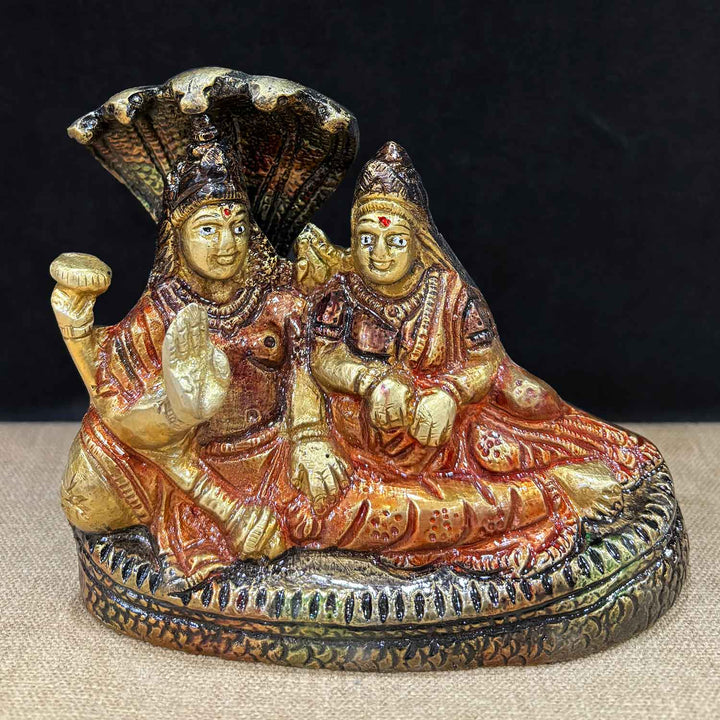4.5-inch brass Vishnu Laxmi idol, with Lord Vishnu and Goddess Laxmi in a graceful seated stance, supported by Sheshnag at the back, symbolizing divine protection and prosperity. Perfect for pooja rooms and spiritual spaces. India’s Largest Pooja Accessories Brand – www.satvikworld.com