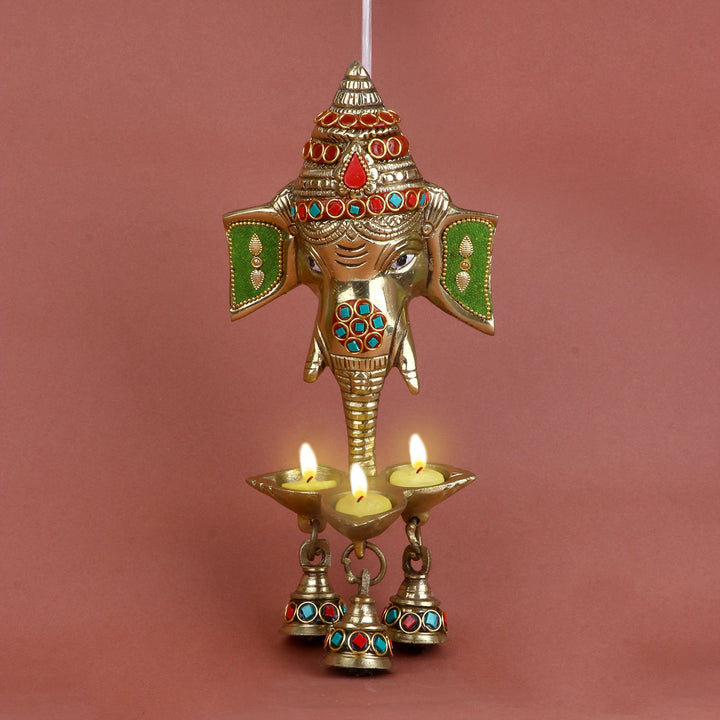 Brass Ganesh face wall hanging with bell and intricate stone work, designed to bring blessings of wisdom, prosperity, and success. Perfect for adorning your home, pooja room, or entrance. India’s Largest Pooja Accessories Brand – www.satvikworld.com