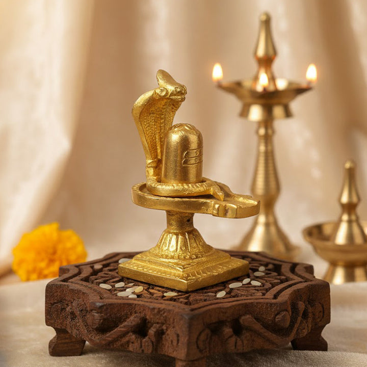3.3-inch handcrafted brass Shivlingam with intricately designed Nag (serpent) surrounding the base, symbolizing divine energy and protection. The idol features detailed craftsmanship, ideal for worship, spiritual practices, or decorative display. India’s Largest Pooja Accessories Brand- www.satvikworld.com