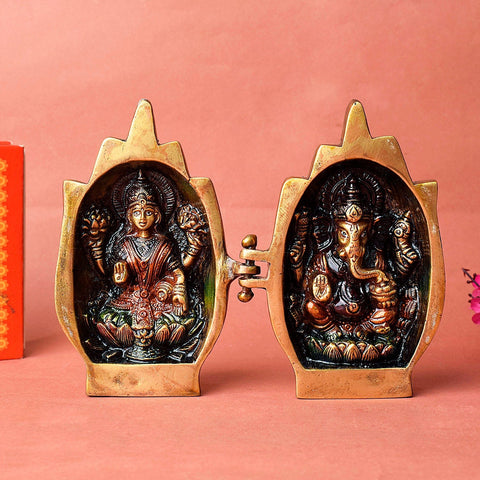 Brass folding shrine featuring intricately carved and painted images of Lakshmi (left) and Ganesha (right). The hinged design opens like a book, with hand-shaped fingers forming the top of each panel. A unique and portable piece for spiritual spaces. India’s Largest Pooja Accessories Brand – www.satvikworld.com