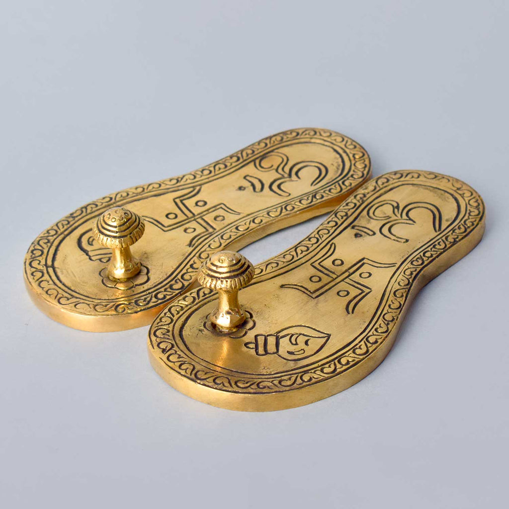 Divine brass Charan Paduka (Khadau), intricately crafted to symbolize the sacred footsteps of deities, ideal for temple or home mandir worship, representing humility, blessings, and devotion. India’s Largest Pooja Accessories Brand – www.satvikworld.com