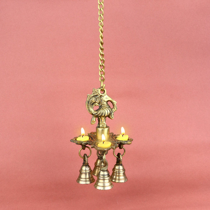 Brass Chaumukh Peacock Hanging Diya with Bells, featuring four wicks and intricate peacock design, perfect for festive occasions and adding a traditional touch to your home decor. India’s Largest Pooja Accessories Brand – www.satvikworld.com